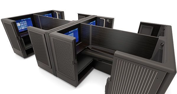 a computer cubicle with a desk and computer screens